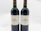 deux bouteilles de vin rouge posées l'une à côté de l'autre sur une surface blanche
