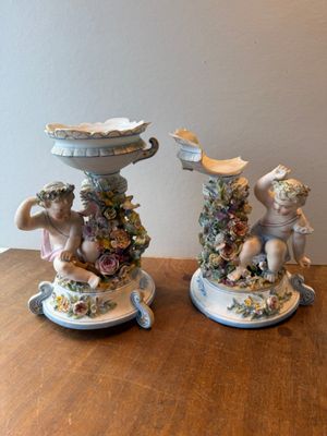two figurines sitting on a table next to each other