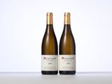 two bottles of wine sitting on top of a table next to each other
