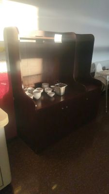une pièce faiblement éclairée avec deux lits et un bureau sur lequel se trouve un ordinateur portable