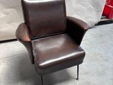 une chaise marron posée sur un sol en béton