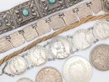 plusieurs types de pièces et de bracelets en argent posés sur un fond blanc