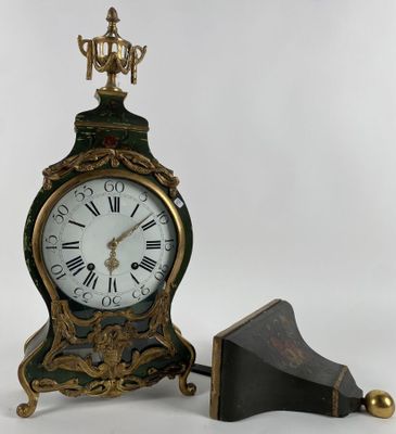 a clock that is sitting next to a small piece of wood