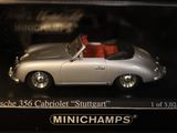 a toy porsche 356 cablet sitting on display in a case