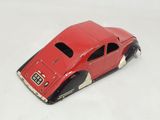 a red toy car that is sitting on a white surface