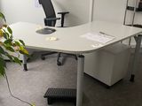 a desk with a chair and a plant in the corner