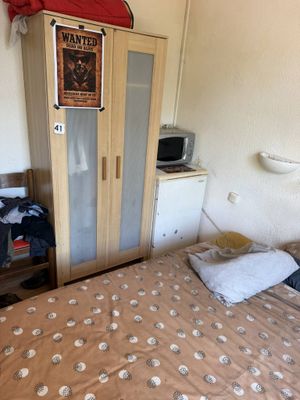 un lit dans une petite chambre avec une tête de lit en bois