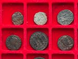 an assortment of roman coins in a red box