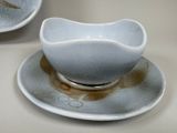 bowl and saucer sitting on a saucer on a table