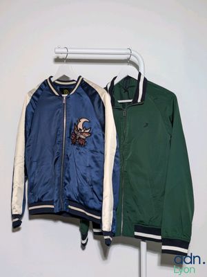two jackets hanging on a hanger in a room
