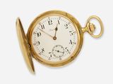 a gold pocket watch with a key in it