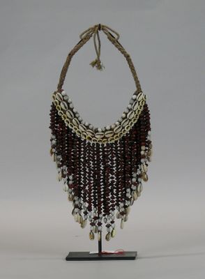 a necklace made of shells and beads on a stand