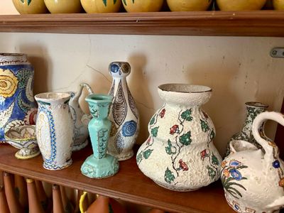 de nombreux vases de toutes sortes posés sur une étagère dans une pièce