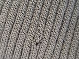 a close up of a knitted hat with a hole in the middle