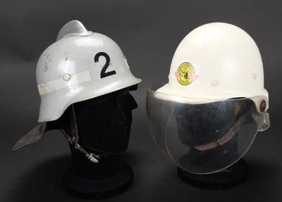 une paire de casques blancs portant les numéros 2 et 2, posés sur une tête de mannequin