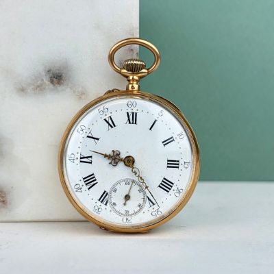 une montre de poche en or avec des chiffres romains