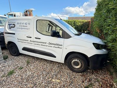 une camionnette blanche garée à côté d'un buisson