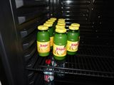 four bottles of juice sitting in an open refrigerator