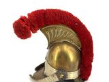 a red and gold helmet with a red pom pom on it