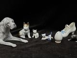 a group of figurines of dogs and cats on a black background