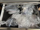 many bags of food in the open drawer of an oven