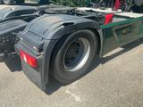 a green semi truck parked in a parking lot