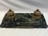 une paire de bougies anciennes en laiton posées sur un socle en marbre