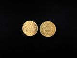 two gold coins on a black background