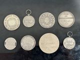six silver medals and a silver medal on a black surface