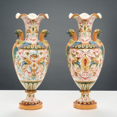 Deux vases sont posés sur une table blanche, sur fond gris.