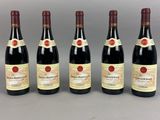 six bottles of wine are lined up on a table
