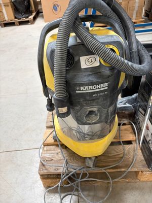 a yellow and black vacuum sitting on a pallet in a warehouse