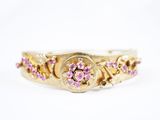 une bague en or jaune sertie de saphirs roses et de diamants