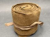 un gros plan sur un rouleau de tissu marron posé sur une surface grise