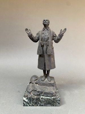 statue d'un homme debout sur un rocher, les bras tendus