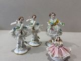 trois figurines en porcelaine représentant des femmes en robe, accompagnées de fleurs posées sur une table