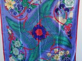 un gros plan sur une écharpe bleue ornée de fleurs et de feuilles