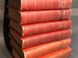 six red books stacked on top of each other on a table