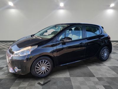 une voiture noire est garée dans une pièce au sol en damier