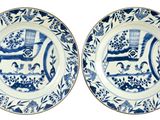 une paire d'assiettes bleues et blanches ornées d'un cheval et d'une calèche