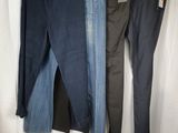 three pairs of jeans hanging on a clothes rack in front of a white curtain