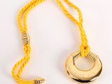 yellow rope with a gold ring and a bead hanging from it