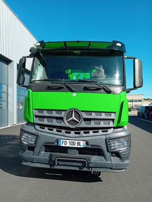 un camion vert garé devant un immeuble