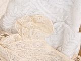 a close up of a white lace bralet on a bed