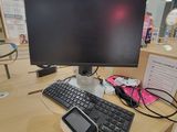 une photo d'un bureau d'ordinateur avec un clavier et un écran