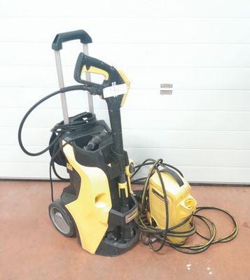 un nettoyeur haute pression jaune et noir posé par terre à côté d'une porte de garage