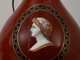 a red vase with a picture of a woman on it