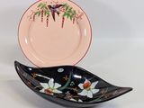 une assiette noire et rose sur laquelle est représenté un oiseau