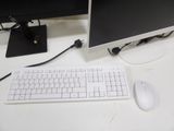 a computer monitor and keyboard on a desk with a mouse