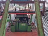 une machine verte qui se trouve au milieu d'une cage